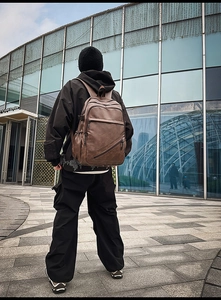 Close-up of brown vintage leather men's backpack with multiple functional pockets