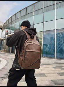 Outdoor shot of vintage brown PU leather backpack for men with functional pockets