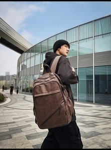 Detailed view of brown leather laptop backpack with multi-pocket design for commuters