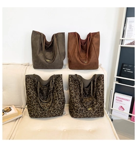Detail of four large tote bags in olive, brown, and leopard print on a sofa