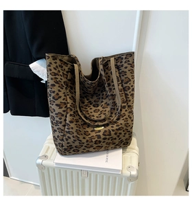 Close-up of leopard print canvas tote bag with dual straps and metal logo detail