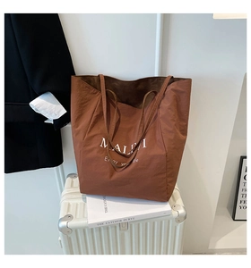 Brown large capacity tote bag detail with text on a suitcase for travel aesthetic