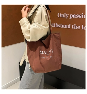 Lifestyle shot of large brown canvas tote bag with white lettering for women commute