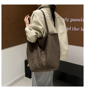 Detail of the brown suede tote bag showing side profile and sleek shoulder strap
