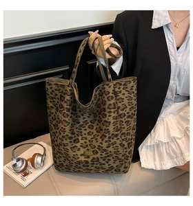 Detail view of large leopard print tote bag featuring a metallic Handmade logo tag