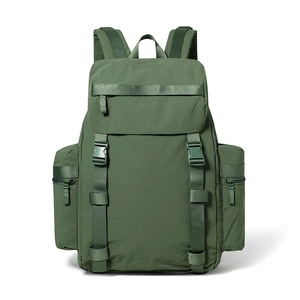 Detail of green 25L outdoor backpack featuring buckle straps and side zipper pockets
