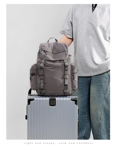 Detail of 25L dark grey outdoor backpack showing buckle closure and side zipper pocket