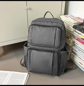 Detail of dark grey business backpack with multi-pocket design and water-resistant fabric