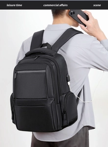Detail of ergonomic padded straps and USB charging port on black business backpack