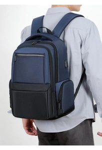 Detail of blue business backpack featuring built-in USB charging port and reinforced handle