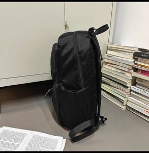 Detail view of the multi-compartment design and ergonomic padded back of this black backpack