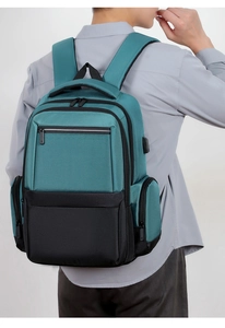 Detail view of teal and black business backpack featuring an external USB charging port