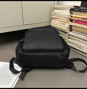 Close-up of black ripstop fabric texture and zipper detail on a durable business backpack