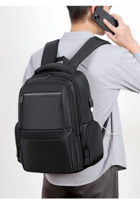 Detailed side view of black commuter backpack featuring external USB charging port