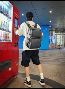 Detailed view of gray water-resistant nylon business backpack with multiple zip pockets