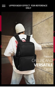 Outdoor shot showing the back view of a black multi-functional backpack on a person