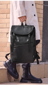 Detail view of a black vintage business laptop backpack with flap top and buckle straps