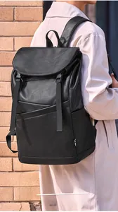 Outdoor shot of a black vintage leather backpack with buckle straps and matte texture