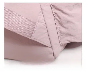 Detailed close-up of reinforced triangular stitching on pink outdoor backpack straps