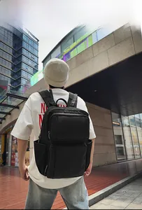 Ergonomic black business laptop backpack with multiple pockets shown on model in urban setting