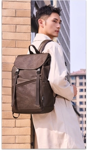 Detail of vintage brown textured leather backpack with flap closure and side logo label