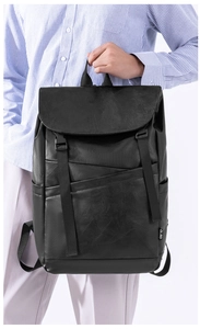 Close-up of black leather backpack featuring buckle closure and white CLBD side label