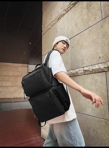 Close-up of the breathable padded shoulder straps and durable textured fabric on black backpack