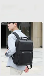 Water-resistant black business backpack with large capacity worn by a male commuter