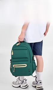 Close-up of dark green canvas backpack with side label and beige leather zipper pulls
