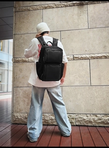 Macro detail of black business laptop backpack with multiple zipper compartments and straps