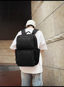 Outdoor shot of a large black waterproof business backpack with multiple zipper pockets