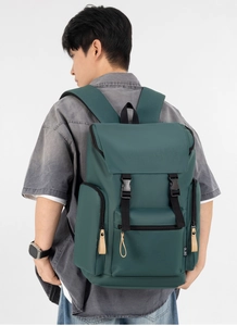 Close-up of a dark green backpack with side zipper pockets and brand logo detail