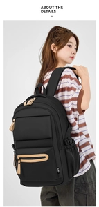 Detail view of durable black nylon backpack with leather pullers and side brand label