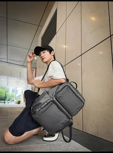 Close-up of a large capacity grey business backpack with multi-pocket design on modern wall