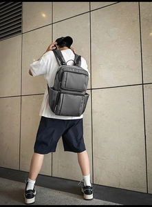 Detailed view of the large grey business backpack with multiple functional compartments