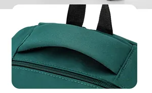 Close-up of the sturdy dark green nylon handle and reinforced stitching on the backpack