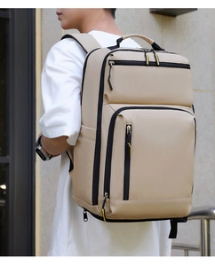 Vue détaillée latérale d'un sac à dos d'affaires beige avec poches zippées et latérales