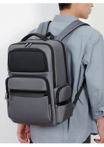Side view of large capacity dark grey business backpack on model with leather trim