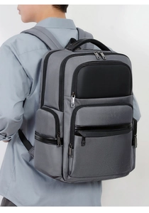 Men's large business backpack in dark gray nylon and black leather trim on model