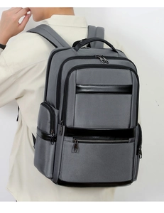 Rear view of grey oxford fabric commuter backpack with leather accents and padded straps