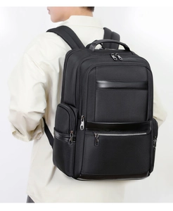Side view of black oxford commuter backpack showing padded straps and multi-pocket design