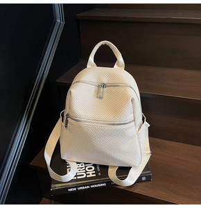 Détail du sac à dos blanc cassé montrant la texture sergé et les fermetures éclair argentées