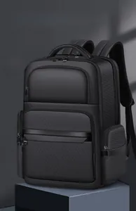 Detail of a black business backpack featuring multiple zipper compartments and top handle