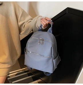 Vue détaillée du sac à dos bleu clair avec texture en nid d'abeille et poches zippées