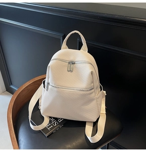Detailed close-up of cream white backpack featuring premium woven texture on black chair