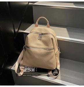 Vue détaillée du sac à dos beige à texture tissée avec fermetures éclair en métal argenté