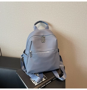 Détail d'un sac à dos bleu avec texture sergé et fermeture éclair en métal sur livres