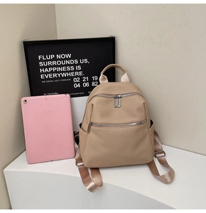 Détail d'un sac à dos de mode beige avec texture tissée et fermetures éclair en métal argenté