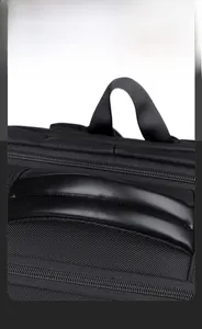 Detail of the dual handle design on a black leather business travel backpack