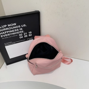 Vue détaillée d'un sac à dos rose en tissu avec poche intérieure zippée et doublure